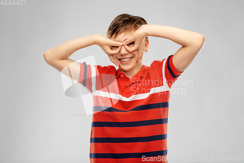 Image of happy smiling boy looking through finger glasses