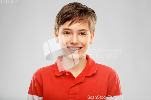 Image of portrait of happy smiling boy in red polo t-shirt
