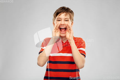 Image of boy in red polo t-shirt shouting or calling