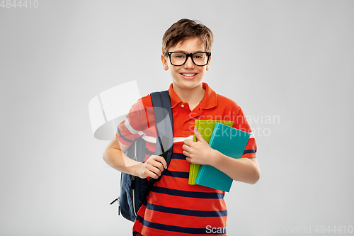 Image of smiling student boy with backpack and books