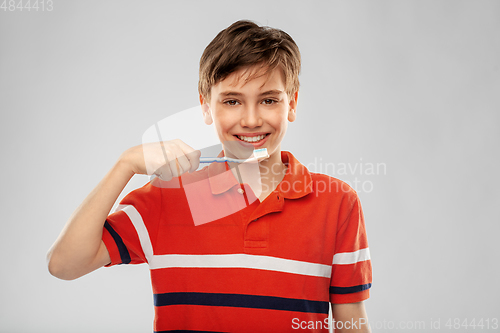 Image of happy boy brushing teeth with toothbrush