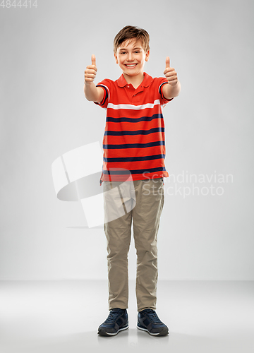 Image of happy boy in red polo t-shirt showing thumbs up