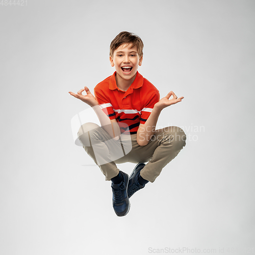 Image of happy smiling young boy flying in air in yoga pose