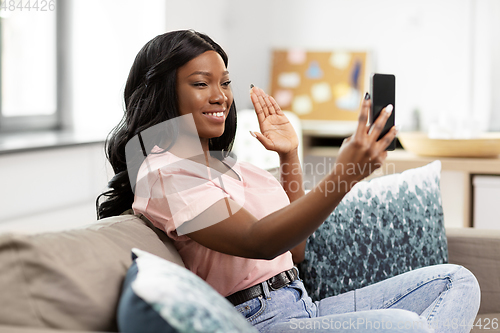 Image of woman with smartphone having video call at home