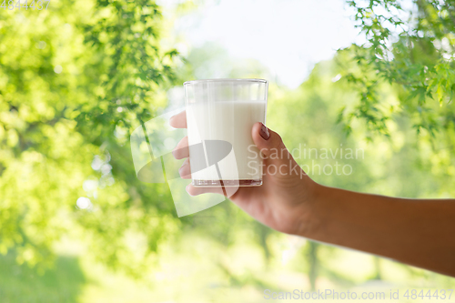 Image of close up of female hand holding glass of milk