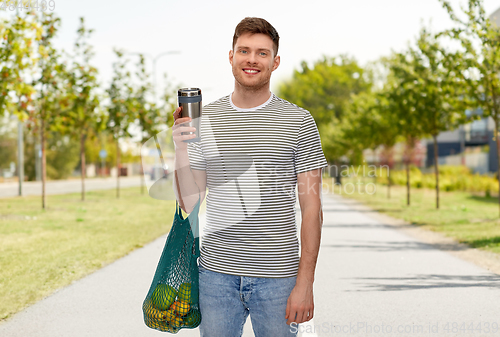 Image of man with food in bag and tumbler or thermo cup