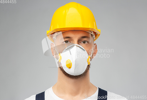 Image of male worker or builder in helmet and respirator