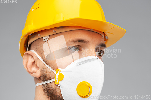 Image of male worker or builder in helmet and respirator