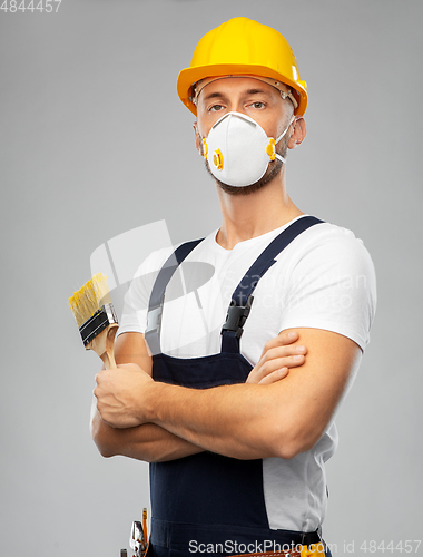 Image of male worker or builder in helmet and respirator