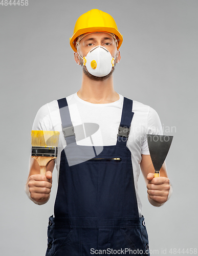 Image of male worker or builder in helmet and respirator