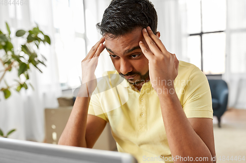 Image of indian man with laptop working at home office