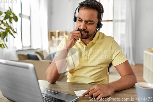 Image of indian man with headset and laptop working at home