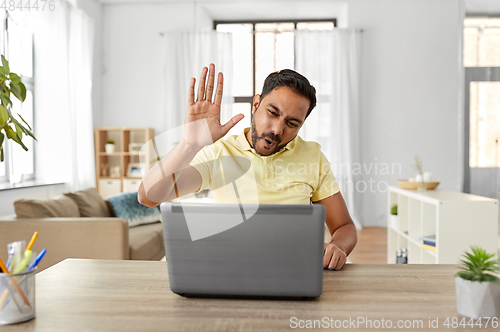 Image of man with laptop has video chat and makes high five