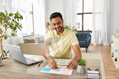 Image of male ui designer working on user interface at home