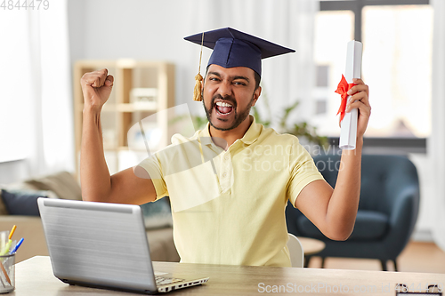 Image of indian student with laptop and diploma at home