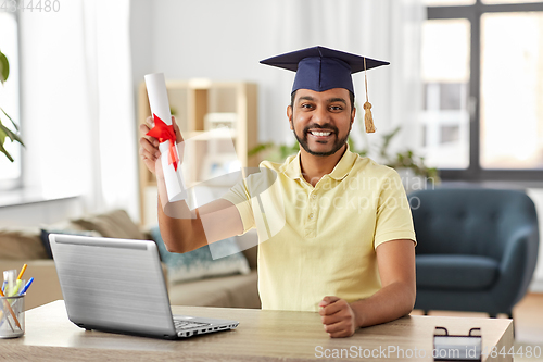 Image of indian student with laptop and diploma at home