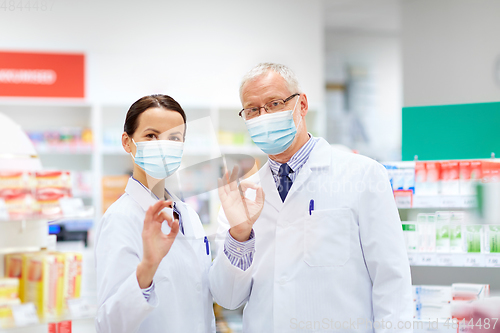 Image of apothecaries in masks at pharmacy showing ok