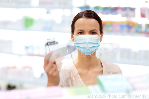 Image of female customer in mask with medicine at pharmacy