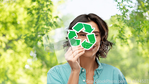 Image of smiling woman looking through green recycling sign