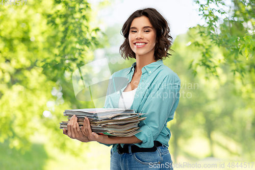 Image of smiling young woman sorting paper waste