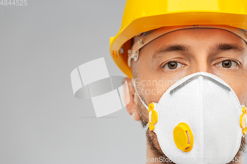 Image of male worker or builder in helmet and respirator