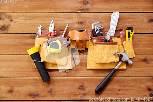 Image of different work tools in belt on wooden boards