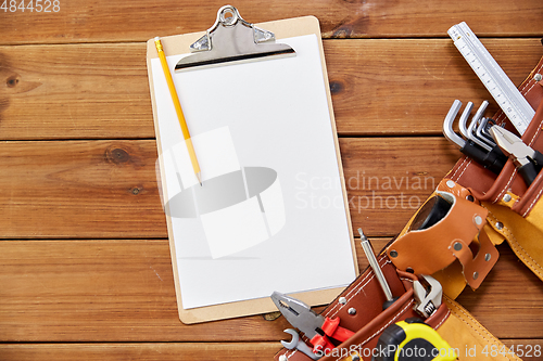 Image of clipboard, pencil and tool belt on wooden boards