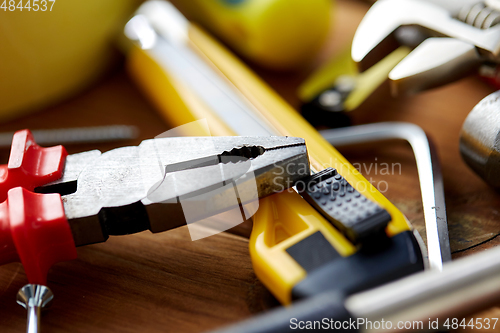 Image of pliers and different work tools on wooden boards