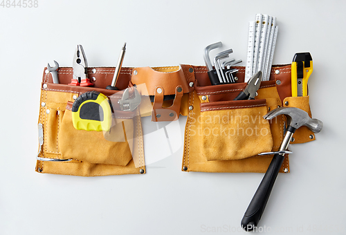 Image of different work tools in belt on white background