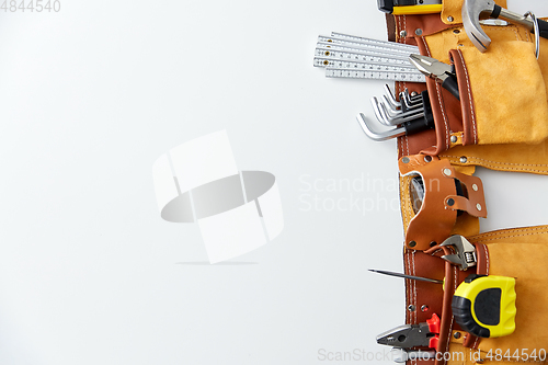 Image of different work tools in belt on white background