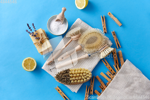Image of cleaning brushes, lemon and wooden clothespins