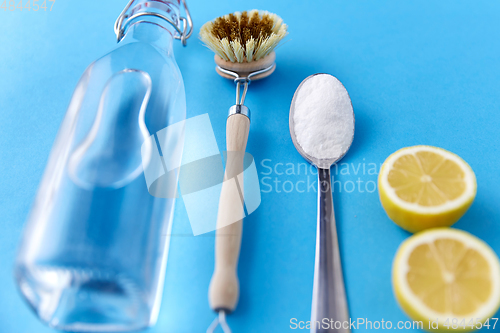 Image of lemons, washing soda, bottle of vinegar and brush