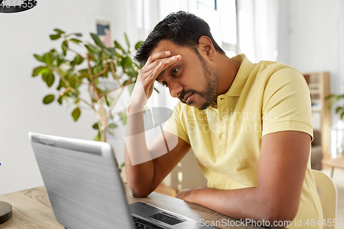 Image of indian man with laptop working at home office