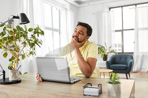 Image of indian man with laptop working at home office