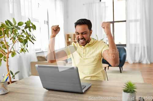 Image of indian man with laptop working at home office