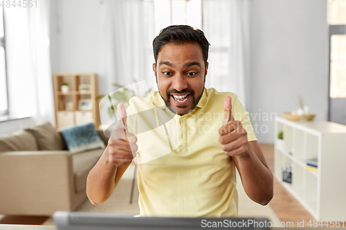 Image of man with laptop has video chat and shows thumbs up