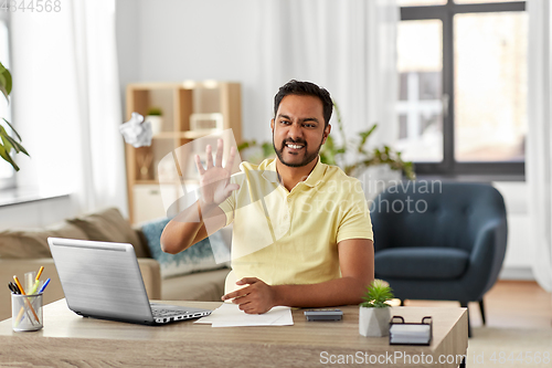 Image of angry man throwing crumpled paper at home office