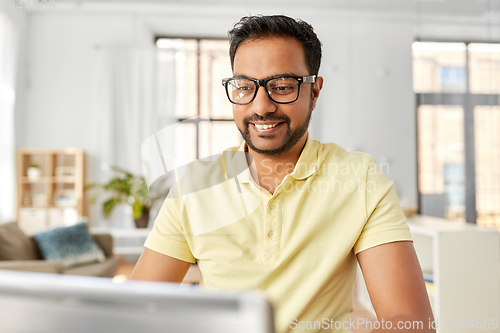 Image of indian man with laptop working at home office