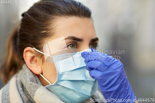 Image of young woman wearing protective medical mask