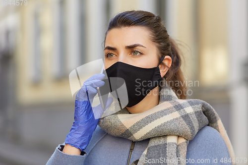 Image of woman in protective reusable mask calling on phone