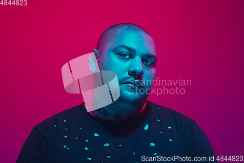 Image of Portrait of a guy with colorful neon light on red background - cyberpunk concept