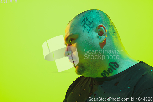 Image of Portrait of a guy with colorful neon light on green background
