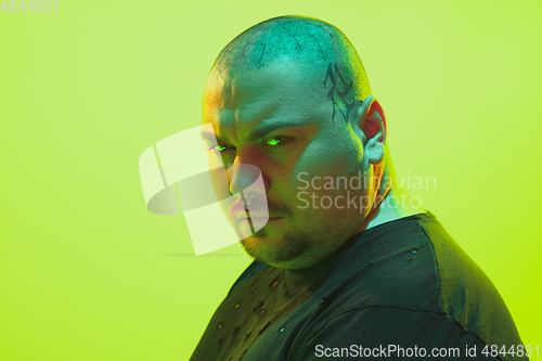 Image of Portrait of a guy with colorful neon light on green background