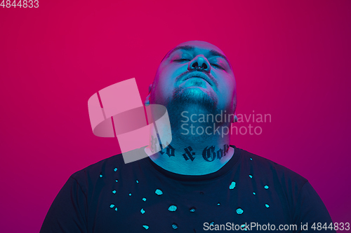 Image of Portrait of a guy with colorful neon light on red background - cyberpunk concept