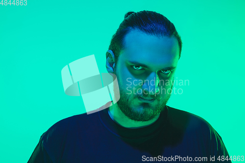 Image of Portrait of a guy with colorful neon light on green background - cyberpunk concept