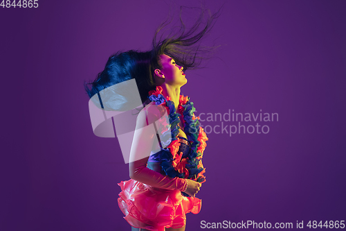 Image of Attractive hawaiian brunette model on purple studio background in neon light