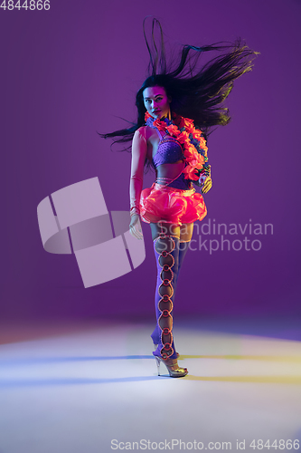 Image of Attractive hawaiian brunette model on purple studio background in neon light