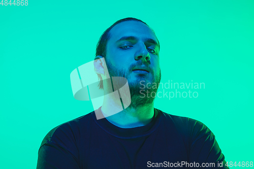 Image of Portrait of a guy with colorful neon light on green background - cyberpunk concept