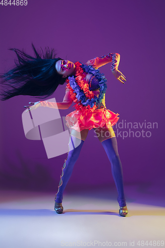 Image of Attractive hawaiian brunette model on purple studio background in neon light