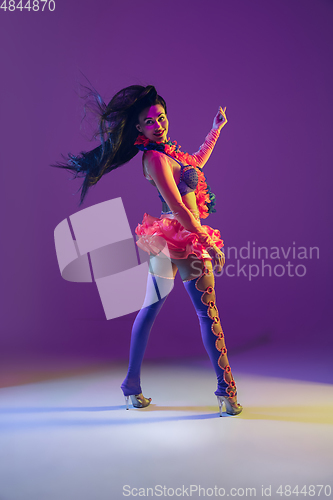 Image of Attractive hawaiian brunette model on purple studio background in neon light